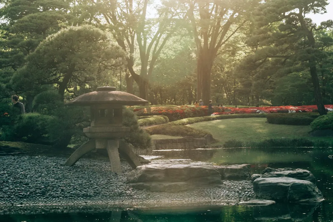 A Japanese garden with a pond and a pavilion
